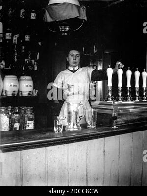 Eine Bardame lehnt sich gegen die Bierpumpen in einem öffentlichen Haus im viktorianischen London, um 1890 Stockfoto