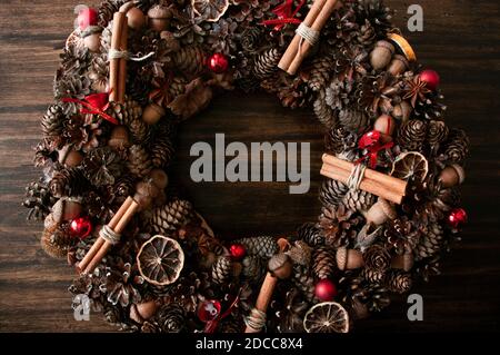 Schöne weihnachten handgemachte rustikalen Kranz mit Pinienzapfen, Eiche, Zimt-Sticks, auf dem alten rustikalen Holzhintergrund, Draufsicht Stockfoto
