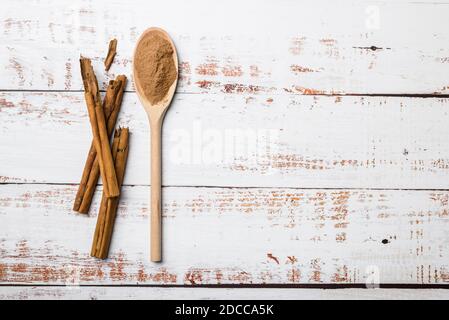 Holzlöffel mit gemahlenem Zimt und Stick auf dem Tisch Stockfoto