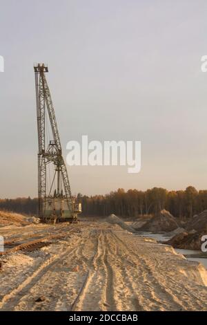 Ein Dragline-Bagger in einem Sandbruch. Phosphoritmine. Reifenspuren auf Sand. Stockfoto