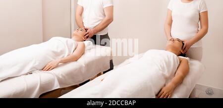 Antistress entspannende Kopfmassage. Glückliche zwei asiatische Frauen, die sich im Spa-Center entspannen. Wochenend-Spa für Freundinnen Stockfoto