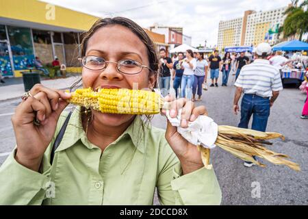 Miami Florida, Springs River Festival fair Hispanic Frau weiblich essen Mais auf Kob, Stockfoto