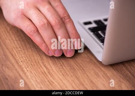 Männlicher Mitarbeiter, der Flash-Laufwerk in den Laptop einsteckt Stockfoto