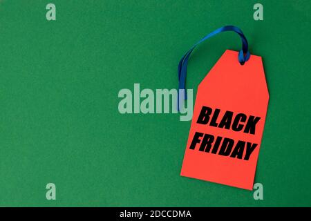 Rotes Papieretikett mit dem Text schwarz Freitag Verkauf geschrieben in ihm vor einem grünen Hintergrund. Black Friday Konzept. Speicherplatz kopieren. Stockfoto