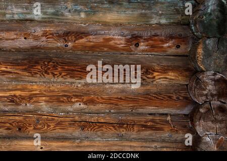 Blockhütte Wand Hintergrund. Alte verwitterte orangefarbene Baumstämme. Holzhintergrund. Stockfoto