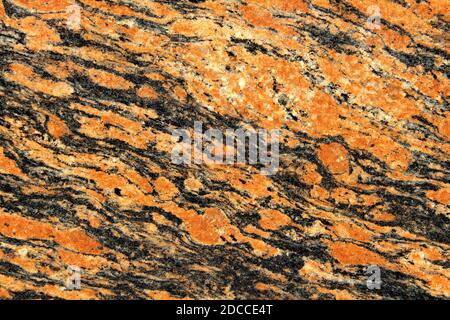 Orange und Schwarz mit weißen Flecken Granitstruktur. Naturstein Hintergrund Stockfoto