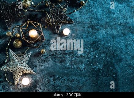 Weihnachtsdekoration Sterne, Lichter und Kerzen auf dunkelblauem Hintergrund Stockfoto