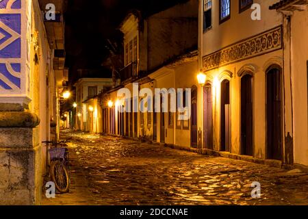 Nachtansicht der Stadt Paraty mit seiner alten Häuser im Kolonialstil und die Helligkeit und Farben der Die Lichter der Stadt spiegeln sich in den gepflasterten Straßen Stockfoto