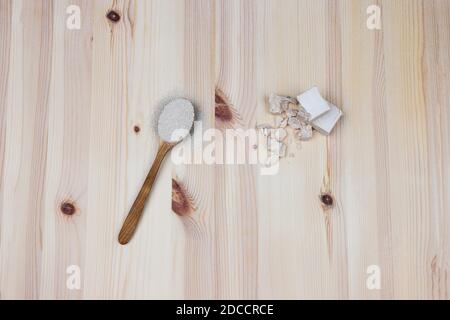 Zwei verschiedene Arten von Hefe auf Holzgrund. Trockene Hefe in einem Holzlöffel und frische Bäcker Hefe in Würfeln und gebrochenen Stücken. Backen und Herstellung br Stockfoto