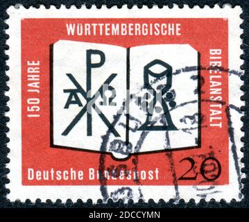 Eine in Deutschland gedruckte Briefmarke, die dem 150-jährigen Württembergischen Bibelinstitut gewidmet ist, zeigt die offene Bibel mit dem Monogramm Christi und dem Kelch. Stockfoto