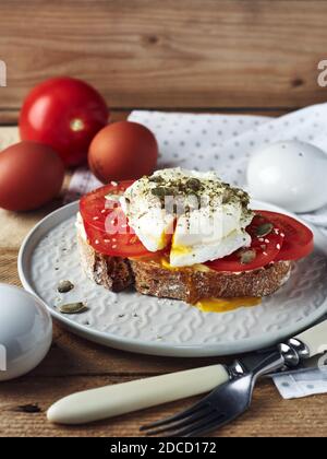 Offenes Sandwich, Toast mit Tomaten und pochiertem Ei. Stockfoto