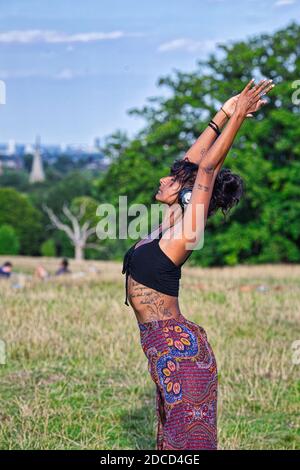 GROSSBRITANNIEN / England / London / Hampstead Heath / Ecstatic Dance London Event . Tänzerin mit geräuschlosen Disco-Kopfhörern. Stockfoto