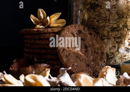 Serviert gesundes Frühstück mit Cornflakes Vollkornmüsli Und Stapel von köstlichen Schokolade hausgemachte Chip Cookies auf einem Vintage dunkel backgro Stockfoto