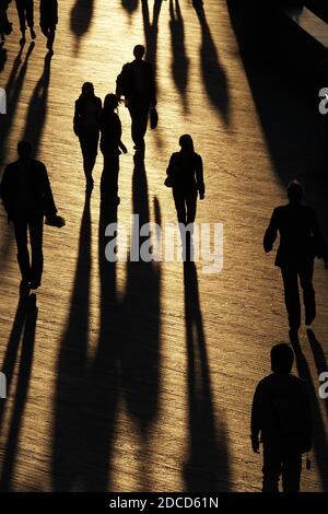 Blick Auf Menschen, Die Während Des Sonnentags Mit Schatten Auf Dem Fußweg Spazieren Stockfoto