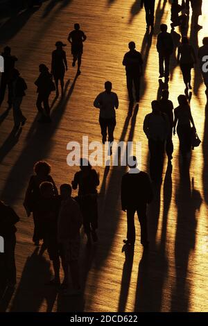 Blick Auf Menschen, Die Während Des Sonnentags Mit Schatten Auf Dem Fußweg Spazieren Stockfoto