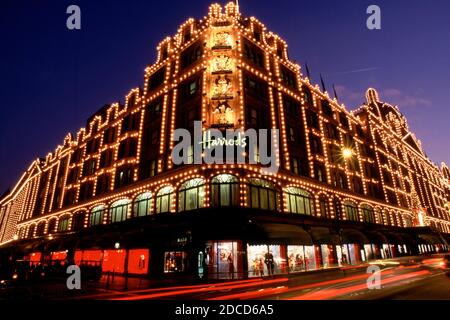 London, Großbritannien, Langzeitaufnahme des Kaufhauses Harrods in London während der Nacht mit Straßenverkehr Stockfoto