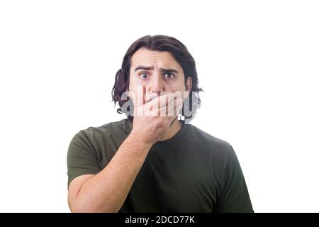 Porträt eines schockierten jungen Mannes, lange lockige Frisur, starrte zur Kamera mit großen Augen, deckt seinen Mund mit der Hand, isoliert auf weißem Hintergrund. Verblüffen Stockfoto