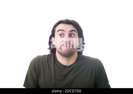 Portrait von frechen jungen Mann zeigt unschuldige, lustige Gesichtsausdruck, Blick zur Seite, rollende Augen und versteckt seinen Blick isoliert auf weißem Hintergrund. Stockfoto