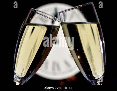 FEIER DES NEUEN JAHRES, Gläser raisen mit Champagner mit der Uhr unfokussiert Stockfoto