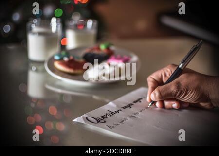 FELIZ DIA DE LOS REYES MAGOS, spanische Übersetzung von GLÜCKLICHEN WEISEN TAG: Kind writting a Letter with the words 'QueridosReyes magos' Stockfoto