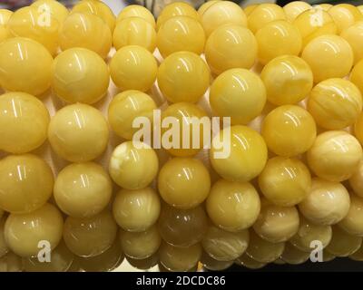 Armbänder aus weißen Baltic Amber Kugeln auf einem Schmuck Steh Stockfoto