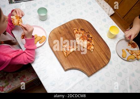 Kinder essen Chicken Dippers und Pizza Stockfoto