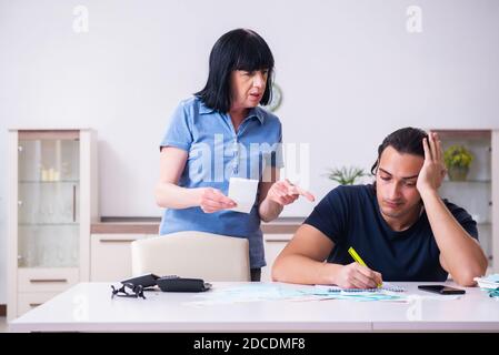 Weibliche Rentnerin und ihr junger Sohn im Budget-Planungs-Konzept Stockfoto