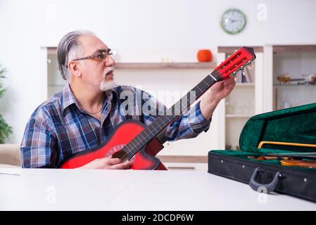 Leitender Mechaniker repariert Musikinstrumente zu Hause Stockfoto