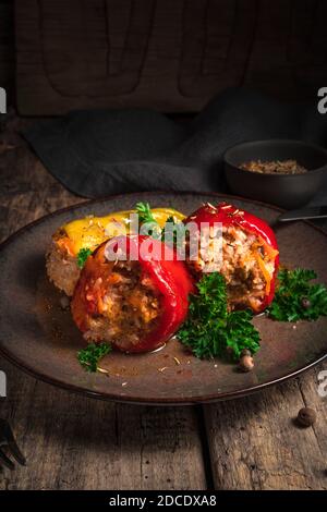 Gefüllter Pfeffer mit Petersilie auf einem hölzernen Hintergrund. Stockfoto