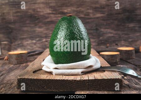 Avocado Nahaufnahme auf einer beigefarbenen Serviette auf dem Brett. Stockfoto