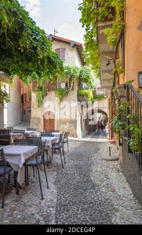 MALCESINE, Italien, 13. Juni 2019: Der kleine Platz der Altstadt am Ufer des Lago di Garda See. Stockfoto