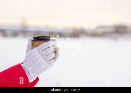 Eine junge Frau hält im Winter ein Glas heiß Kaffee oder Tee Stockfoto