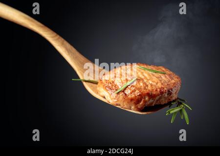 Köstliches hausgemachtes Schnitzel mit Rosmarin auf schwarzem Hintergrund. Stockfoto