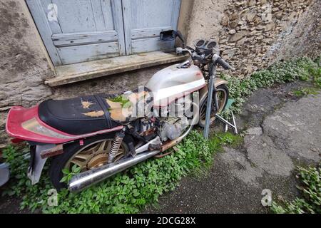 Verlassene Motorrad mit Moos auf dem Sattel Stockfoto