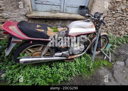 Verlassene Motorrad mit Moos auf dem Sattel Stockfoto