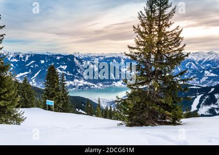 Zell am See und Schmitten Stadt am Zeller See im Winter. Blick vom Schmittenhohe Berg, verschneite Skiabfahrt in den Alpen, Österreich Stockfoto