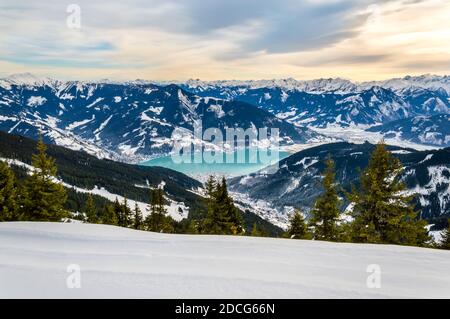 Zell am See und Schmitten Stadt am Zeller See im Winter. Blick vom Schmittenhohe Berg, verschneite Skiabfahrt in den Alpen, Österreich Stockfoto