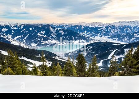 Zell am See und Schmitten Stadt am Zeller See im Winter. Blick vom Schmittenhohe Berg, verschneite Skiabfahrt in den Alpen, Österreich Stockfoto