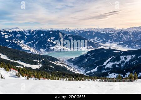 Zell am See und Schmitten Stadt am Zeller See im Winter. Blick vom Schmittenhohe Berg, verschneite Skiabfahrt in den Alpen, Österreich Stockfoto