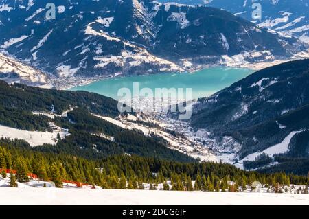 Zell am See und Schmitten Stadt am Zeller See im Winter. Blick vom Schmittenhohe Berg, verschneite Skiabfahrt in den Alpen, Österreich Stockfoto