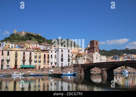 Ein sonniger Tag in Bosa, Sardinien, Italien entlang der Uferpromenade des Temo. Farbenfrohe Häuser reflektieren das Wasser und tragen zum Charme dieser historischen Stadt bei Stockfoto