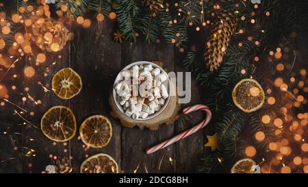 Weihnachten Hintergrund Zuckerrohr Zweige heiße Schokolade Getränke getrocknete Orangenscheiben auf dunklem Holzhintergrund. Urlaubskarte. Draufsicht flach liegend. Christus Stockfoto