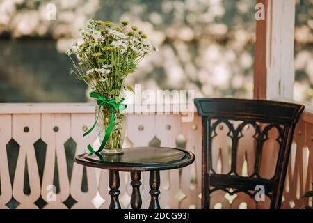 Ein Haufen Kamillen in Vase auf Holztisch Stockfoto