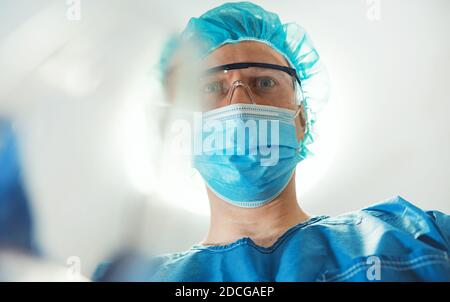 Männlicher Anästhesist, der dem Patienten Gasmaske gibt. Stockfoto