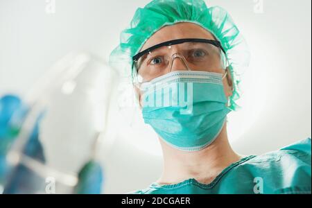 Männlicher Anästhesist, der dem Patienten Gasmaske gibt. Stockfoto