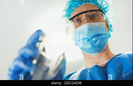 Männlicher Anästhesist, der dem Patienten Gasmaske gibt. Stockfoto