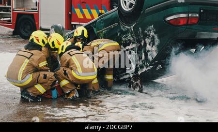 Feuerwehrleute, die Person vor einem Autounfall retten. Hochwertige Fotos Stockfoto