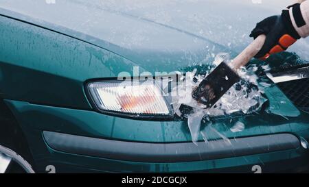 Nahaufnahme, Mann Hand brechen Auto Lichter mit großen Hammer. Hochwertige Fotos Stockfoto