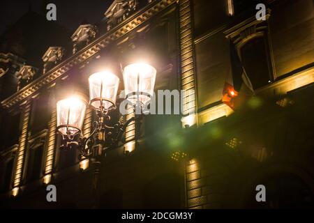 Straßenlaterne, Paris, Frankreich. Wunderschöne POV-Aufnahme eines alten Eisenlampenpostens in der Stadt der Lichter. Faszinierende Beleuchtung mit einem Lichtreflexe. Stockfoto