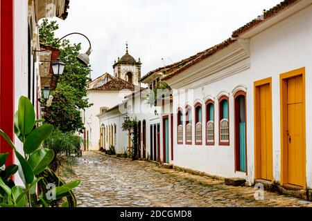 Kopfsteinpflaster Straße im historischen Zentrum von Paraty mit alten kirche im Hintergrund Stockfoto